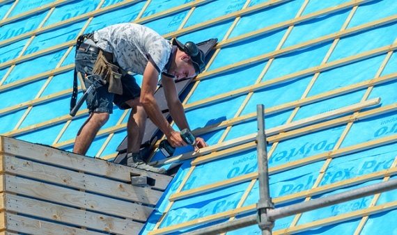 Man aan het werk op bouwsteiger