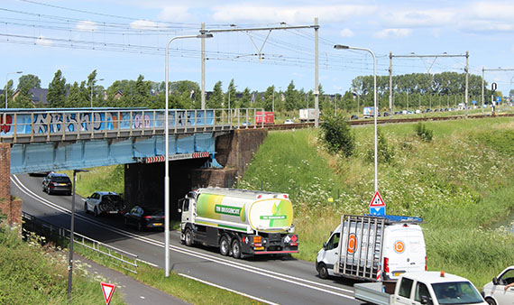 Wegverkeer op de N242 bij het spoorviaduct