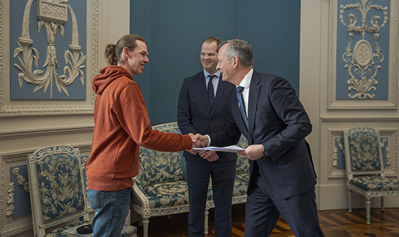 Commissaris van de Koning Arthur van Dijk schudt de hand van Dennis Boon bij zijn beëdiging als hulpstrandvonder Texel.